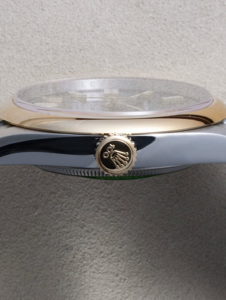 Profile analysis showing the smooth yellow gold bezel geometry and centenary crown markings.